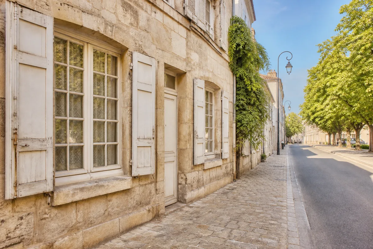 Façade ancienne en pierre et fenêtres à petits carreaux dans une rue de Pontoise